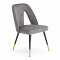 Chaise en velours gris avec pieds en métal et détails dorés